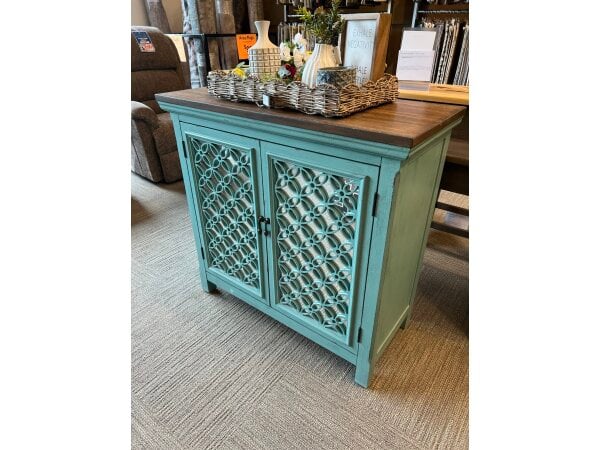 Teal accent cabinet with mirrored lattice doors and wooden top.